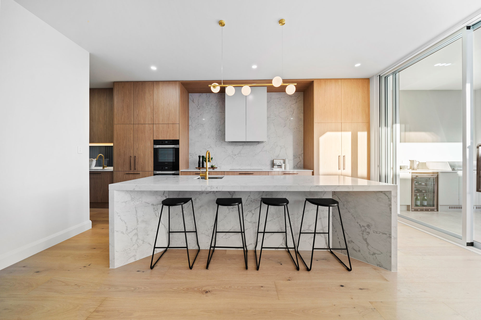 Geometric kitchen design with stone benchtop island, and stone splash backs. Uniq Stone job