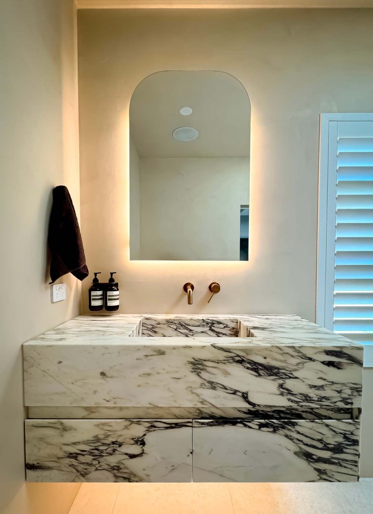 Luxurious Calacatta Viola marble integrated stone basin with matching stone drawer fronts.